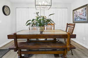 Dining area featuring a notable chandelier, baseboards, and wood finished floors