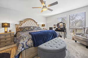 Carpeted bedroom with a ceiling fan