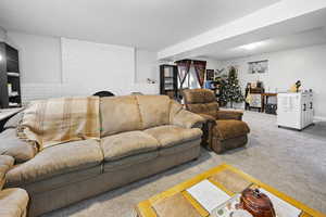 Living room featuring brick wall, carpet, a fireplace, and a textured ceiling