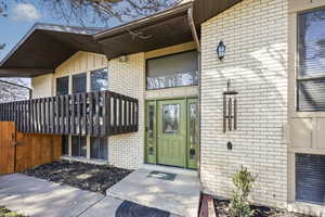 Entrance to property featuring board and batten siding and brick siding