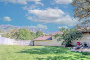 View of yard featuring a patio area, fence, and a mountain view