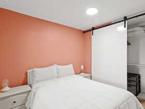 Bedroom featuring a barn door and wood finished floors
