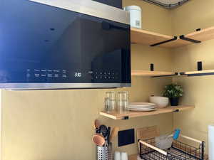 Kitchen view of shelves and microwave