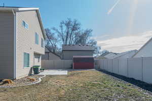 View of yard with an outbuilding, a patio, a storage shed, and a fenced backyard