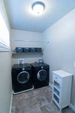 Laundry area with laundry area, separate washer and dryer, and baseboards