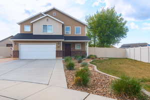 View of front of home with fence, a garage, a porch, and brick siding