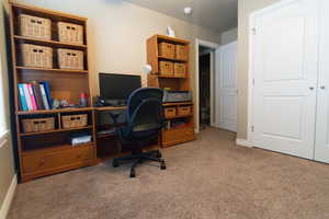 Carpeted office space featuring baseboards