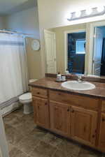 Bathroom with a shower with shower curtain, vanity, and toilet