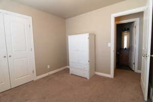 Unfurnished bedroom with carpet and baseboards