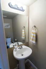 Bathroom with toilet, tile patterned flooring, baseboards, and a sink