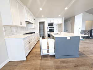 Kitchen featuring light wood-style flooring, white cabinetry, stainless steel appliances, and a sink