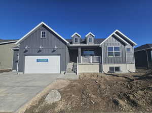 View of front of house with covered porch, concrete driveway, board and batten siding, and an attached garage