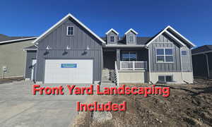 View of front facade featuring driveway, a porch, board and batten siding, and an attached garage