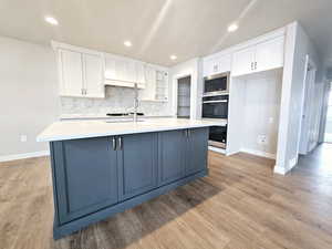 Kitchen with stainless steel appliances, light countertops, and white cabinets