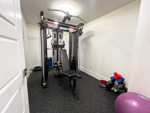 Exercise area featuring a textured ceiling and baseboards