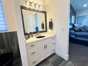 Ensuite bathroom featuring connected bathroom, vanity,