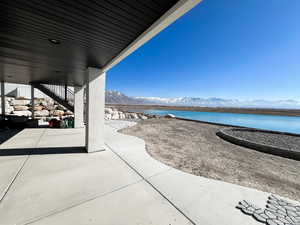 View of patio / terrace featuring a water and mountain view and stairs