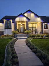 Entrance to property with stone siding, board and batten siding, beautiful landscaping