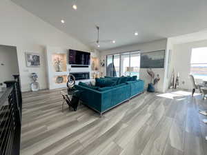 Living room with a glass covered fireplace, a wealth of natural light, and LVP floor