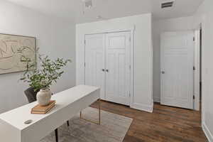 Office featuring dark wood-style floors, visible vents, and baseboards