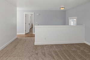 Spare room featuring carpet and baseboards