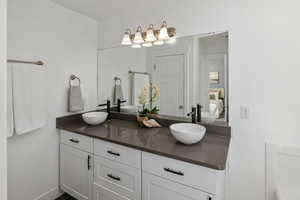 Ensuite bathroom with double vanity, a sink, and connected bathroom