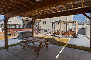 View of patio featuring fence, a mountain view, and a hot tub