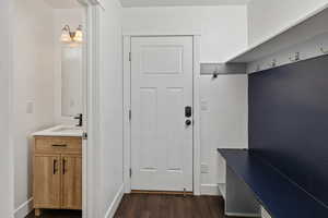 Mudroom featuring dark wood-style flooring and a sink