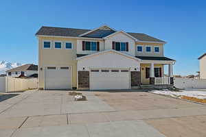 Craftsman inspired home with an attached garage, driveway, fence, and a porch