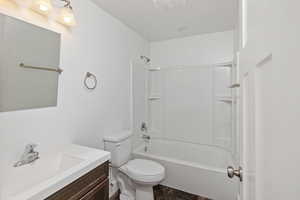 Bathroom featuring toilet, shower / bathtub combination, and vanity