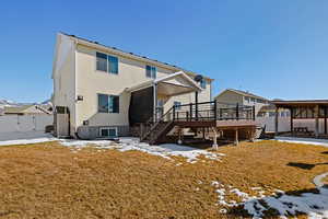 Snow covered property with a deck, fence, stairway, and a patio