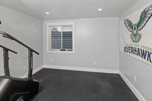 Interior space with baseboards, concrete flooring, and recessed lighting