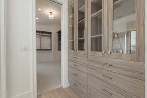 Walk in closet with wood finished floors