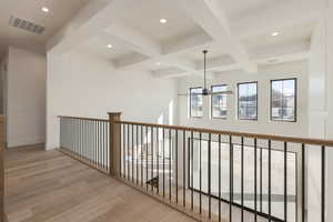 Hallway with visible vents, coffered ceiling, wood finished floors, beamed ceiling, and recessed lighting