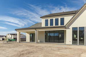 Rear view of house with a patio and stucco siding