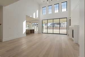 Unfurnished living room with light wood-style floors, visible vents, and baseboards