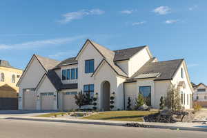 View of front of home featuring fence, driveway, a gate, stucco siding, and a front lawn