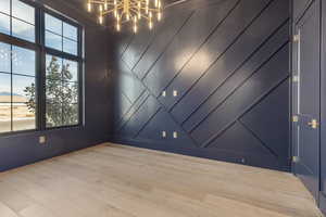 Spare room with an inviting chandelier and light wood-style flooring