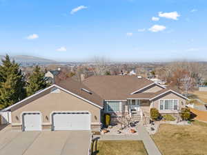 Ranch-style house featuring driveway, an attached garage, fence, a mountain view, and stucco siding