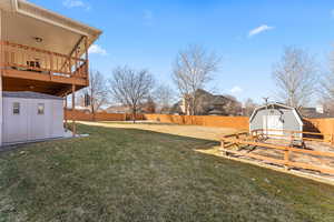 View of yard featuring a storage shed, a fenced backyard, and an outdoor structure