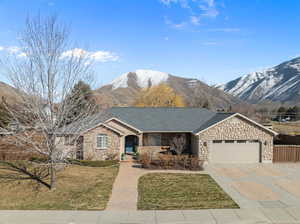 Ranch-style home featuring stone siding,  and a mountain view