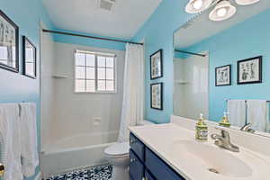 Full bath featuring shower / tub combo, visible vents, toilet, tile patterned floors, and vanity