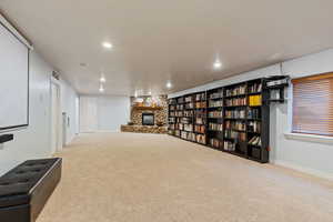 Basement game/theater room featuring a fireplace and projector