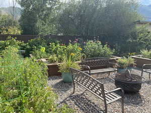 View of patio / terrace with a fire pit, fence, and a vegetable garden