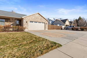 Exterior space featuring a mountain view, driveway, an attached garage, and fence