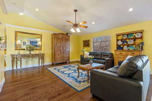 Living area featuring lofted ceiling, wood finished floors, and recessed lighting