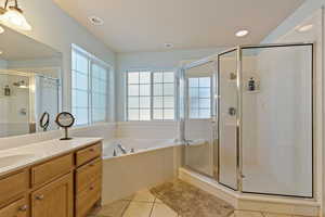 Full bath featuring a garden tub, tile patterned flooring, vanity, a shower stall, jetted tub and recessed lighting