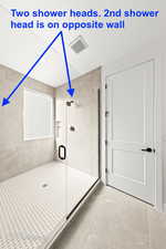 Bathroom with a shower stall and visible vents