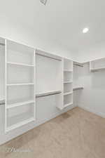 Walk in closet with carpet floors, a wall unit AC, and visible vents