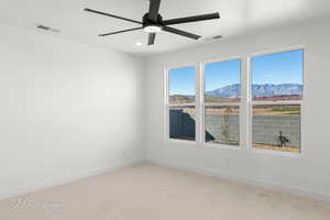 Spare room featuring baseboards, visible vents, a mountain view, and light colored carpet